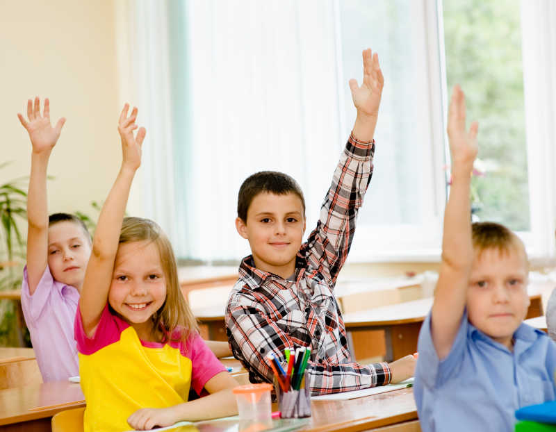 课堂上积极举手回答问题的孩子们