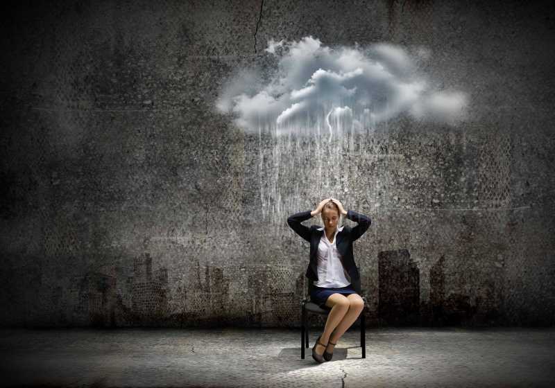 烦恼的年轻商人坐在雨中