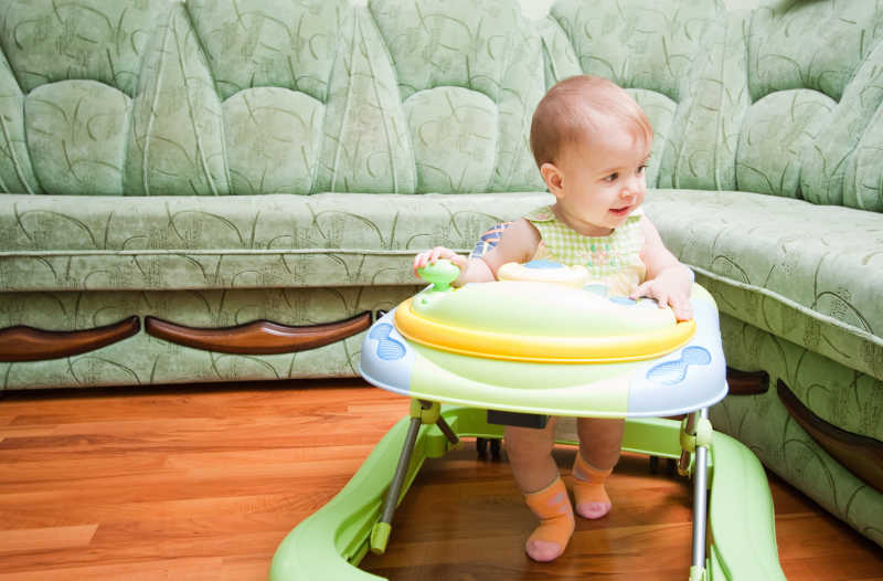 坐在学步车练习走路的婴儿