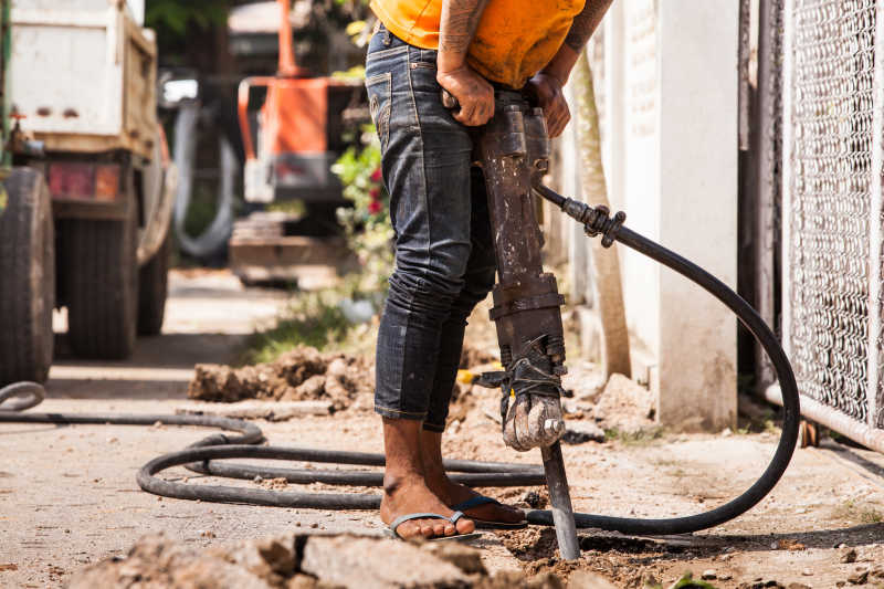 手拿冲击钻工作的人