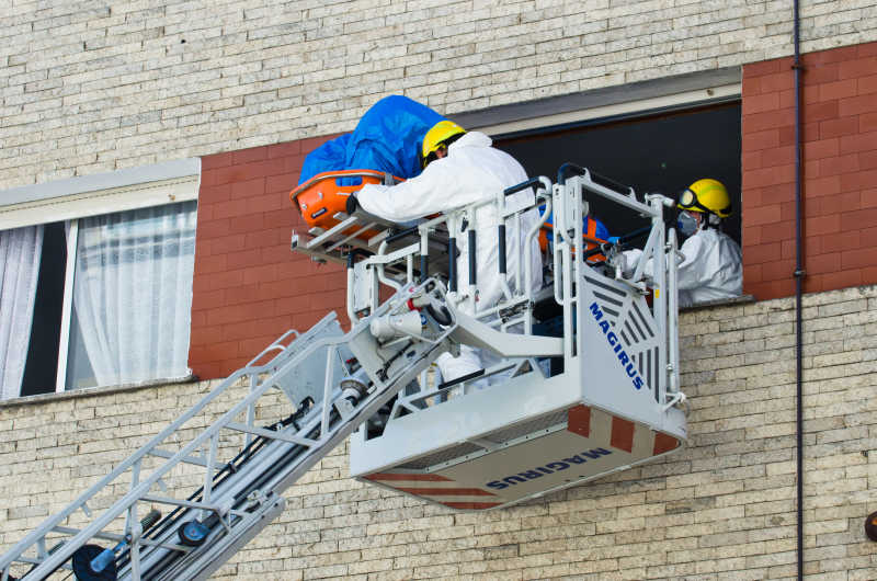 消防队员正在利用云梯搬运一具尸体