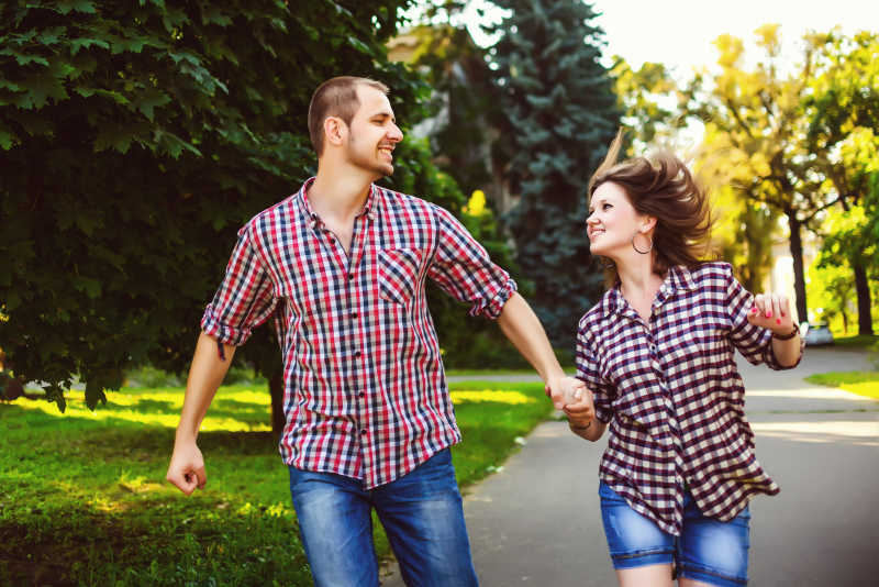 年轻的情侣开心的在公园里奔跑