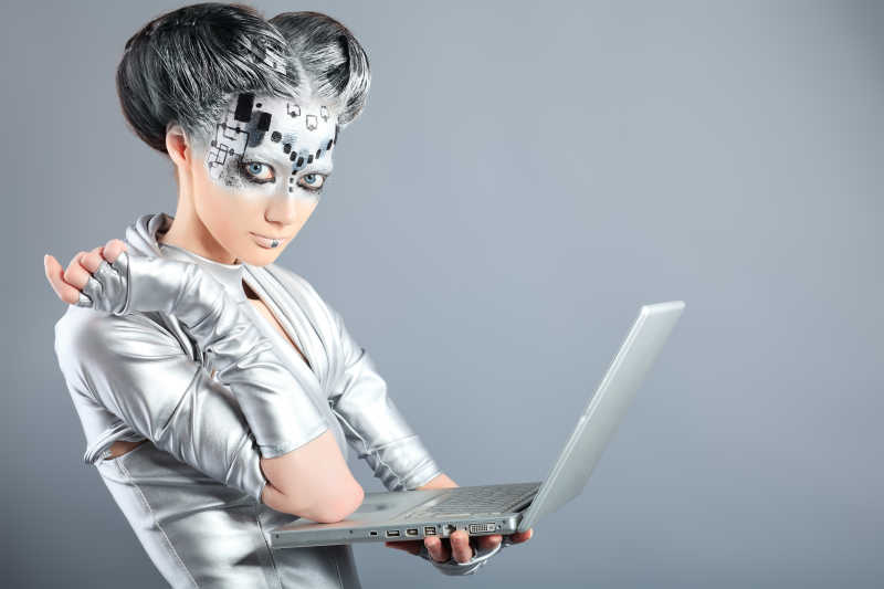 一个未来的年轻女子用笔记本电脑正在拍摄