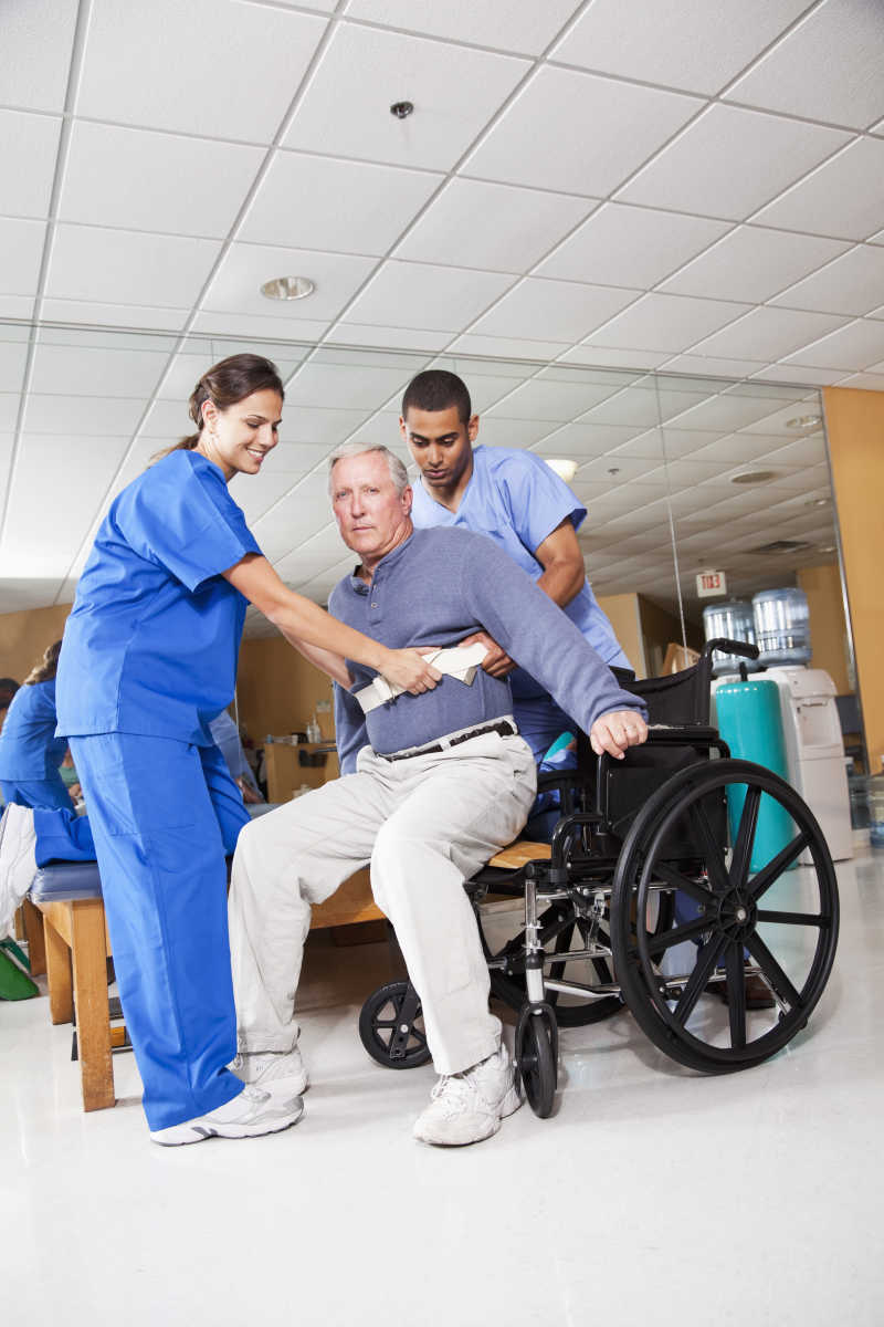 干净整洁的医院里医护人员帮助病人坐轮椅