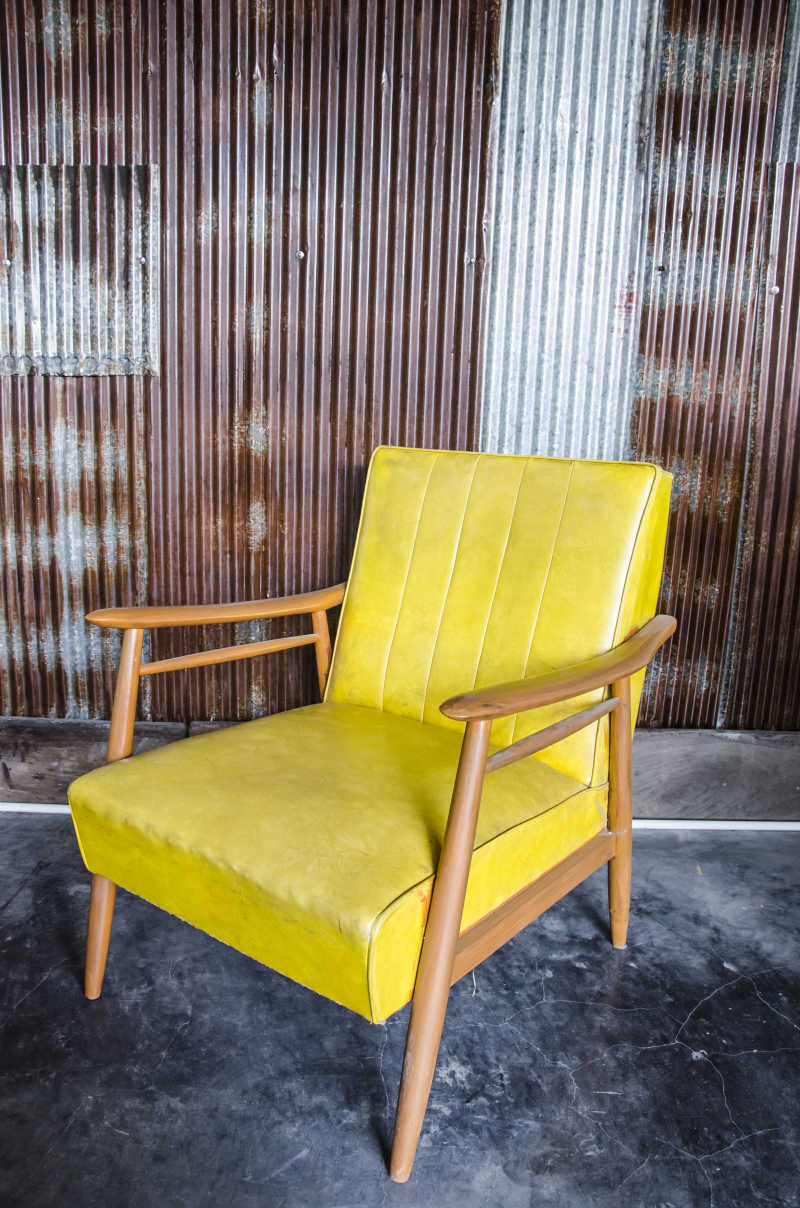 锌墙房间中的黄色椅子