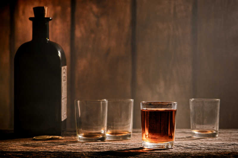木材柜台上威士忌酒瓶和杯子
