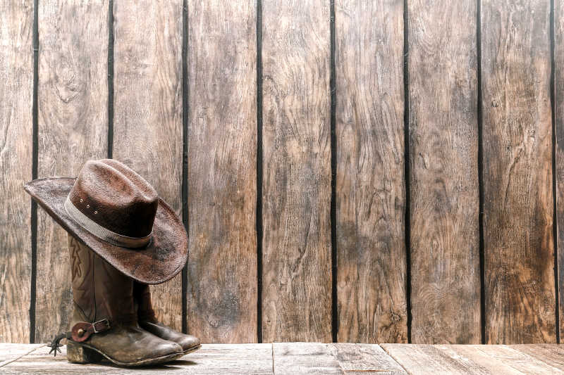 木板上棕色牛仔帽和靴子