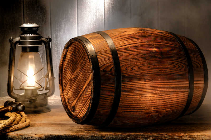 被灯光照射的古老的威士忌木桶或乡村葡萄酒桶