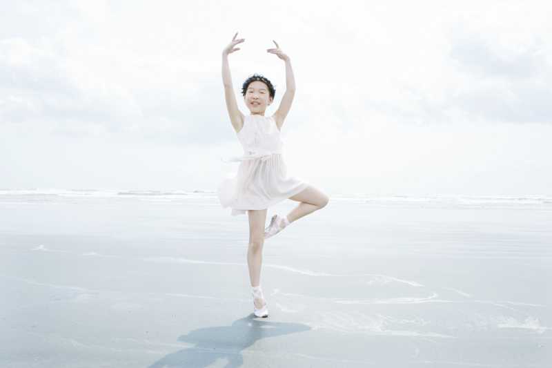 穿着白色连衣裙的跳舞小女孩