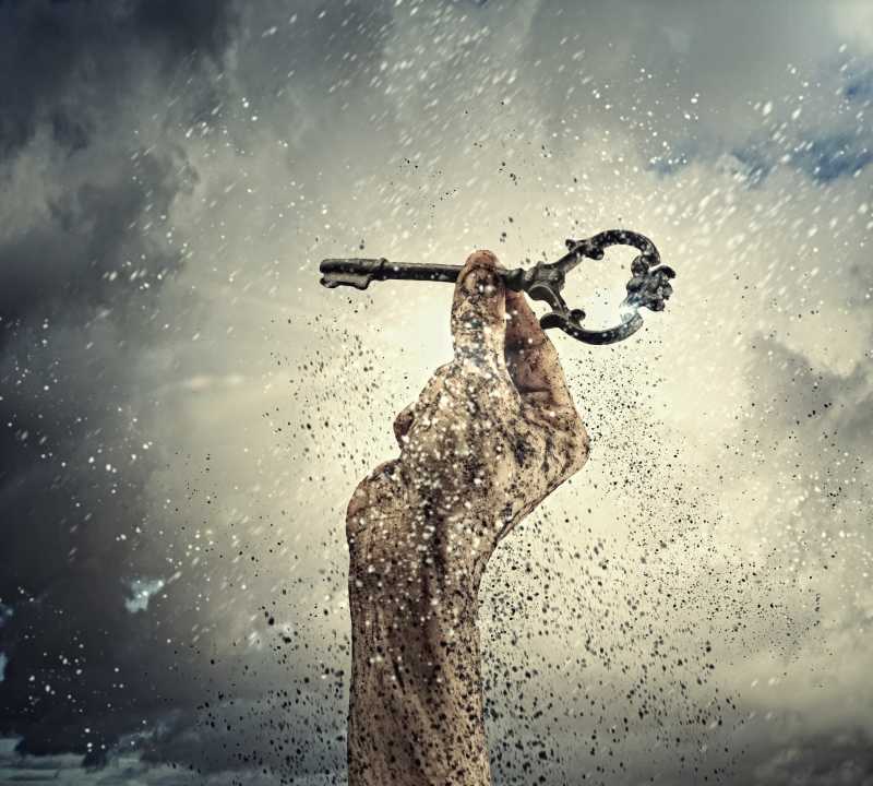 厚厚的云层背景前拿着钥匙的手