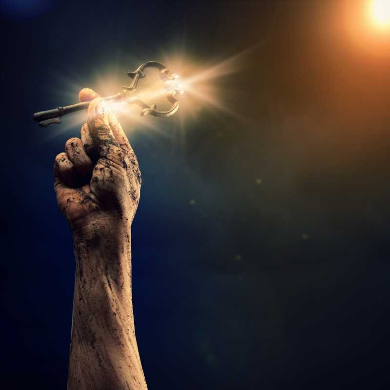 深蓝色宇宙背景下拿着钥匙的手