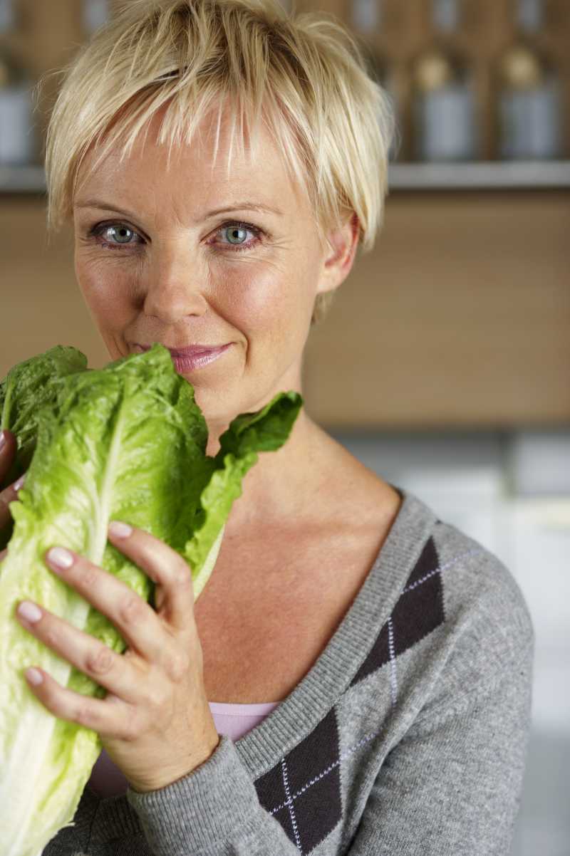 中年妇女手里拿着一棵白菜