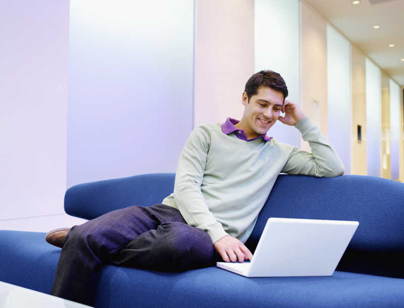 休闲的看着笔记本电脑的商人