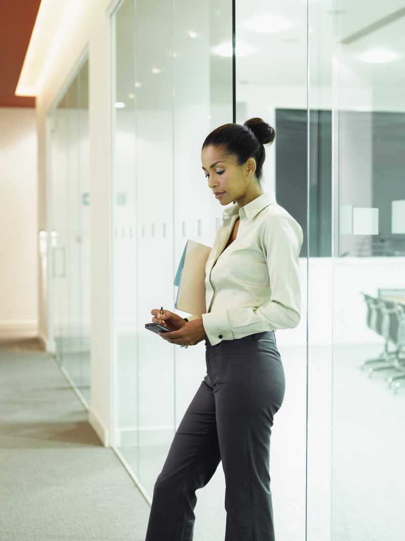 年轻的看着手机的女商人