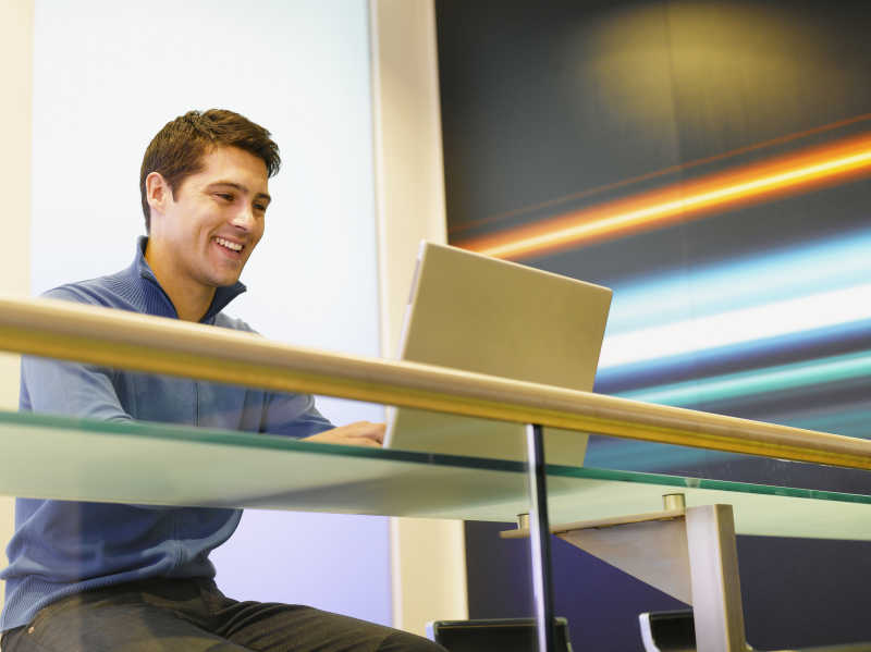 使用笔记本电脑微笑的商人