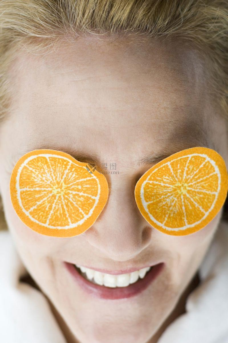 眼睛上盖有柠檬片的妇女 