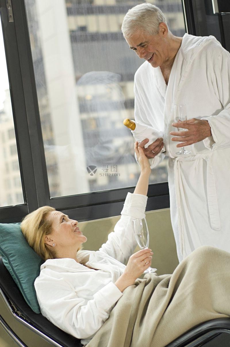 水疗休息室喝香槟的中年夫妇