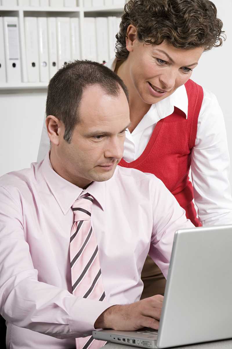 看着笔记本电脑的两个商人