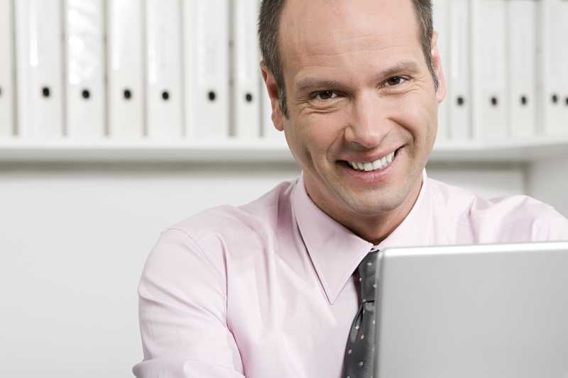 笔记本前微笑的商人