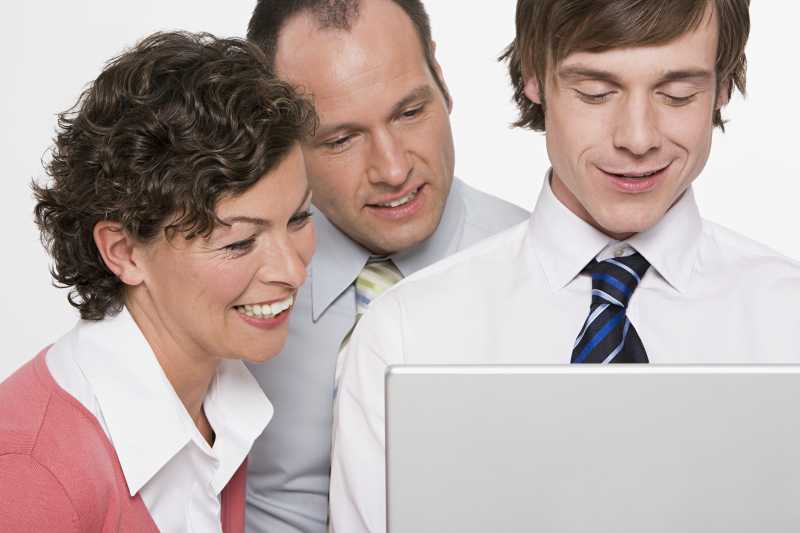 看着电脑的三个商人