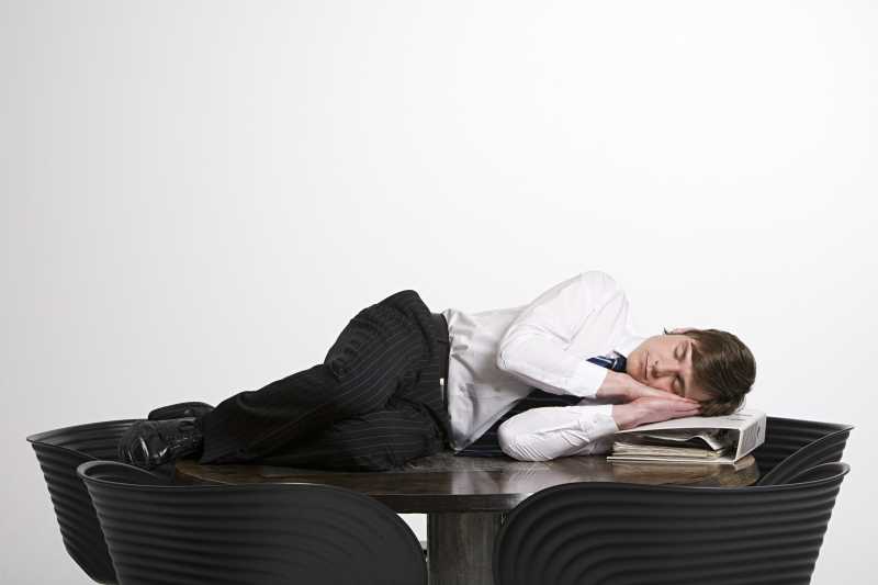 在办公桌上睡着的青年