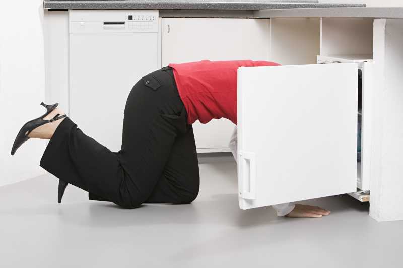 钻进柜子找东西的中年女性