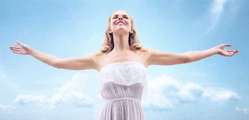 蓝天下穿着白色裙子的美女