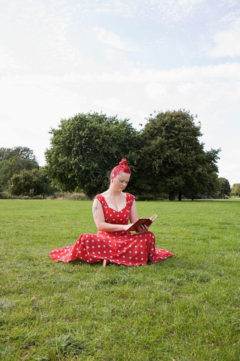 在草地上坐着看书的女演员