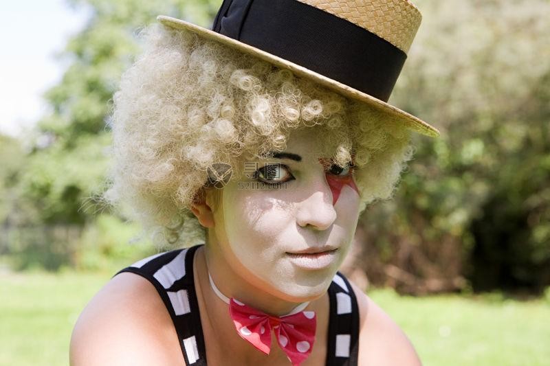 带着礼帽假发画着小丑装的女人