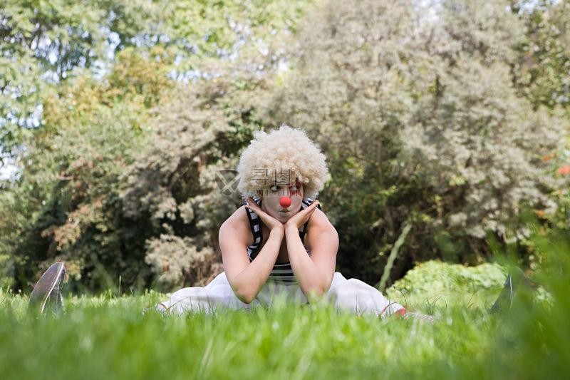 坐在草地上的女小丑