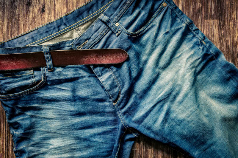 精致的蓝色牛仔裤和老式皮带的细节
