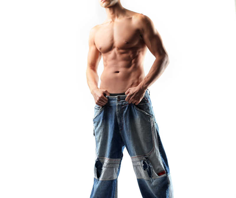 一个强壮的男人穿着宽松牛仔裤
