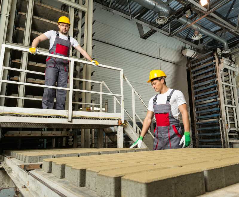 工厂里戴着安全帽的工人和工头