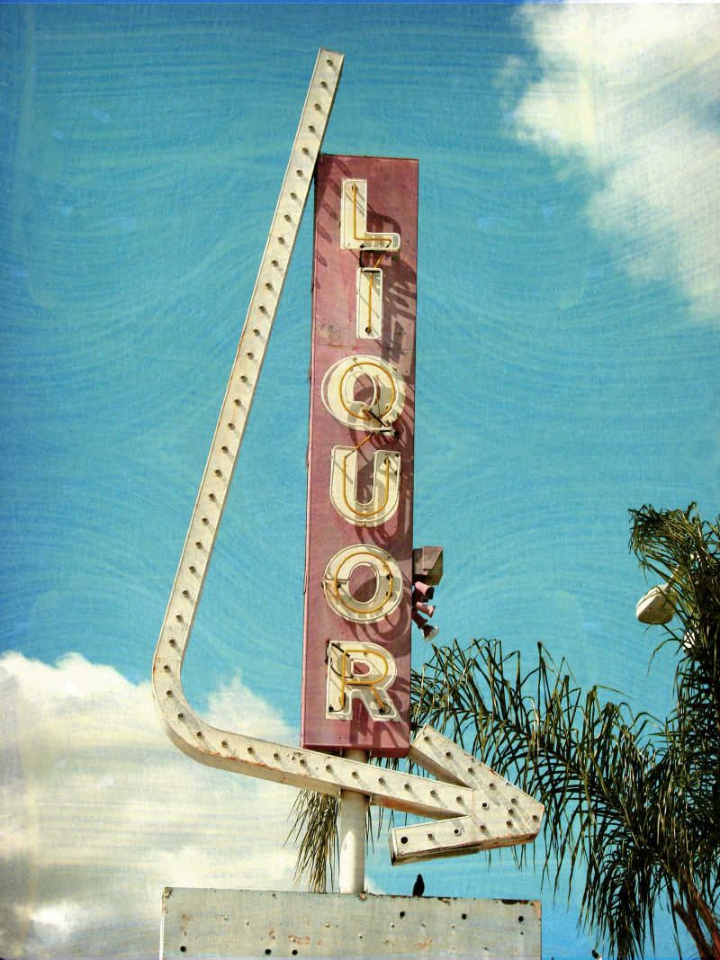 蓝天白云背景下复古的带有霓虹灯的指示牌