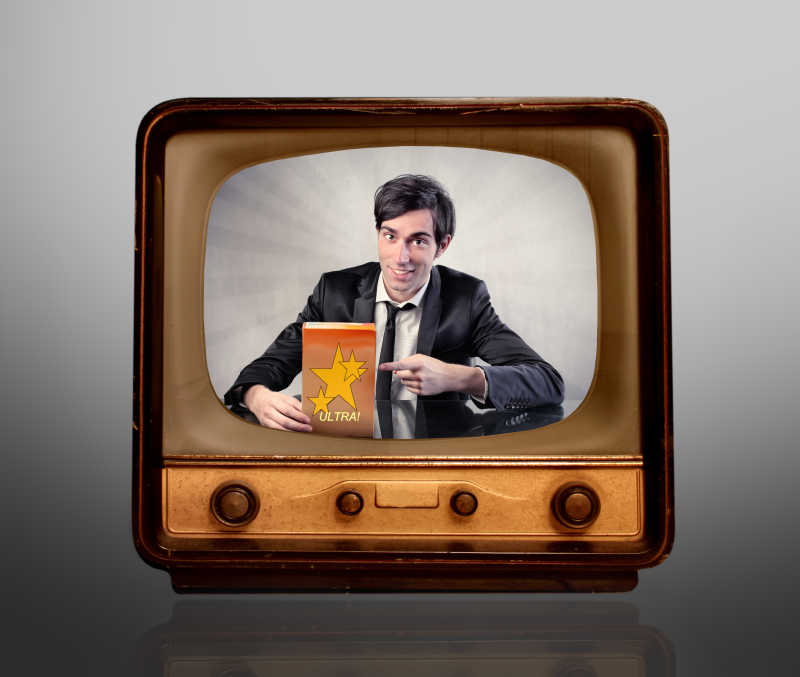 灰色背景下在复古老式电视上做广告的人