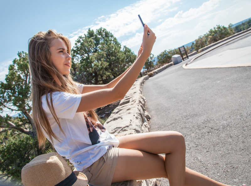 美女在户外用手机自拍