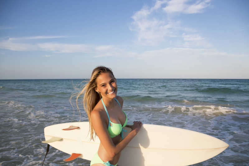 海边拿着冲浪板的美女