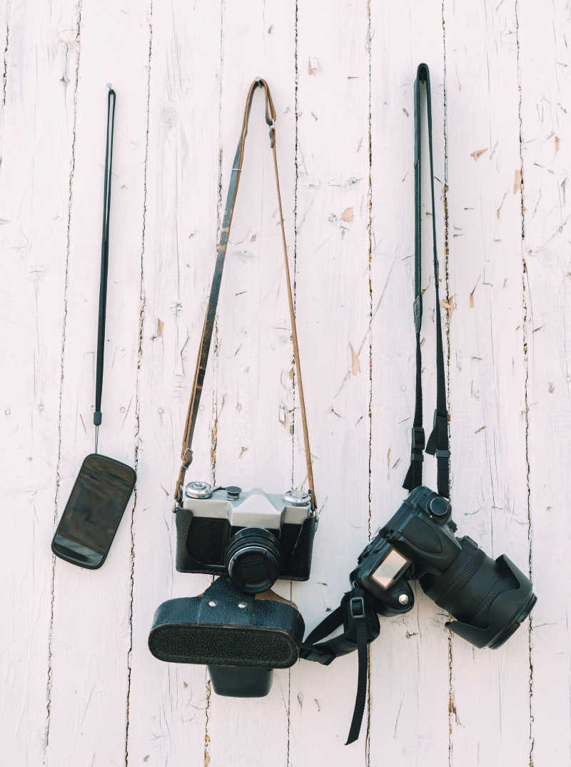 木墙上挂着相机和手机