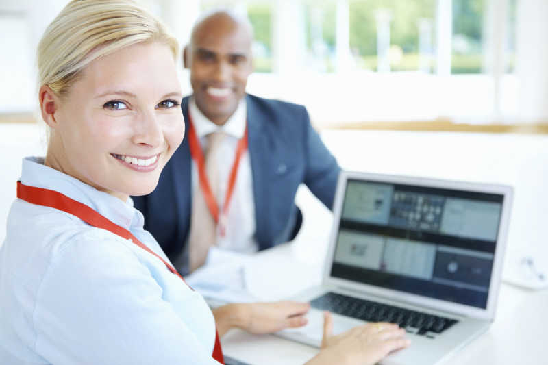 与同事一起使用笔记本电脑的主管