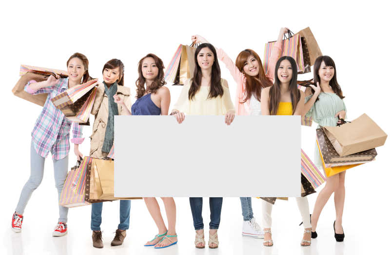 迷人的亚洲妇女购物和空白广告牌
