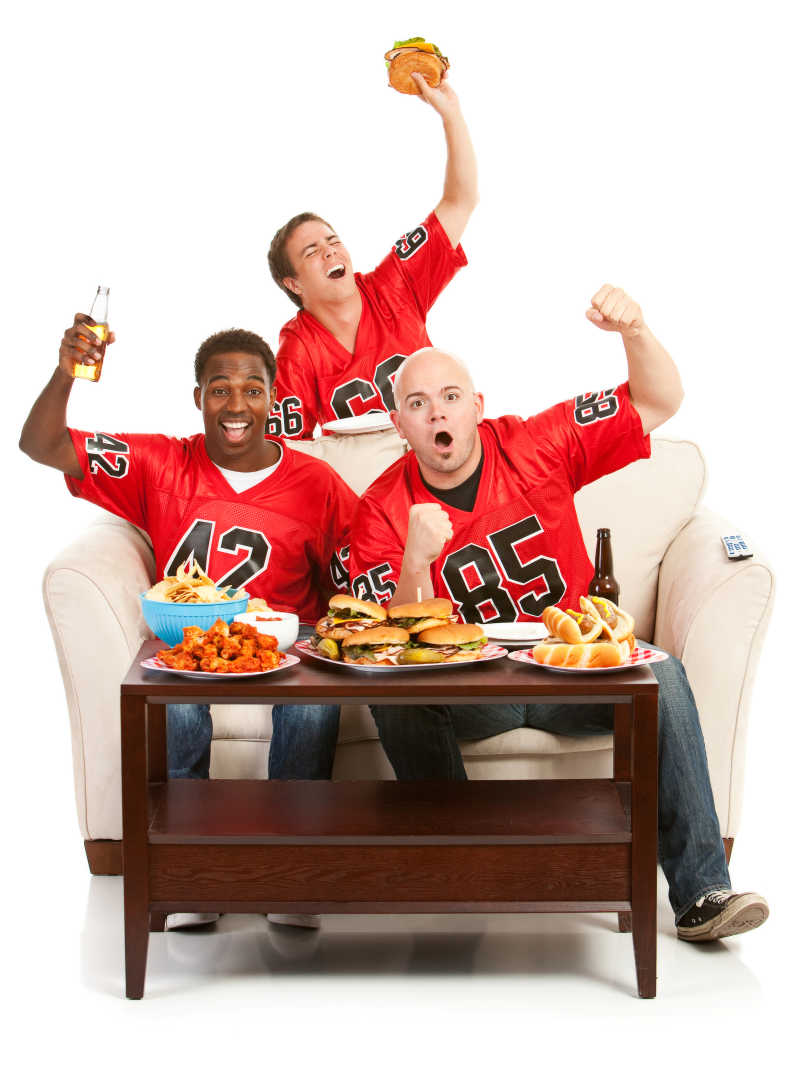 在食物和饮料的沙发上兴奋地欢呼的球迷