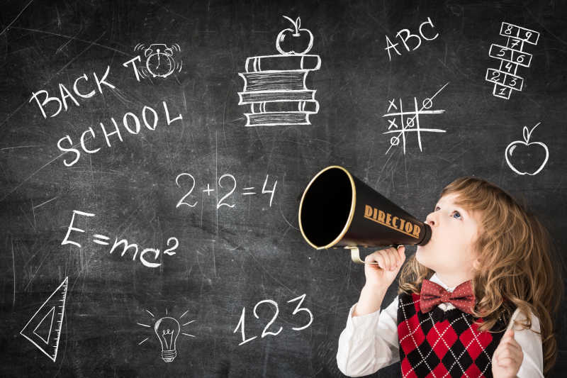 写满字的黑板前的孩子拿着老式扩音器喊