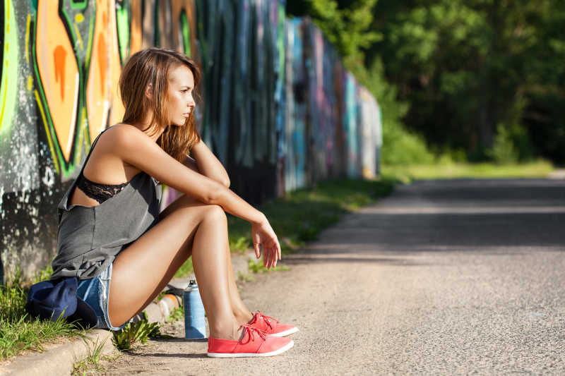 带着水壶坐在路边的女性跑者