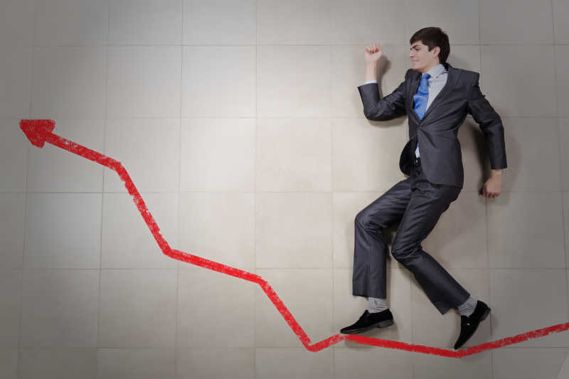 年轻商人谨慎的走在一个上升的箭头上