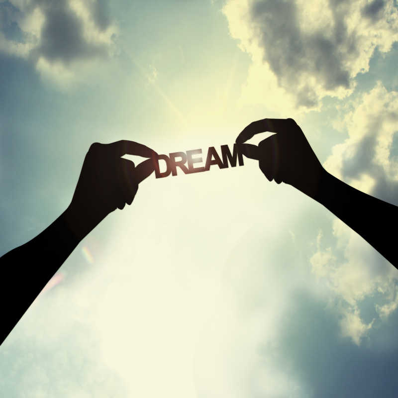 手持dream字样剪纸的手