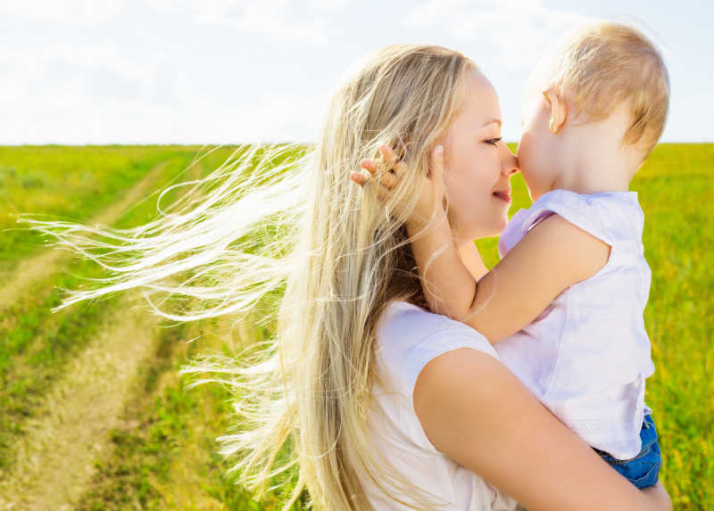 夏天户外年轻的妻子与她的女儿