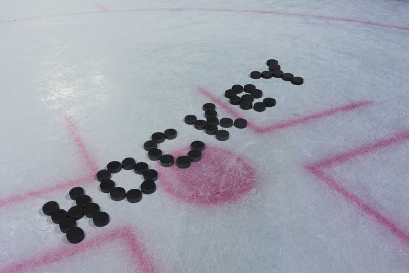 比赛场地上一个用冰球拼凑的hockey字样图案