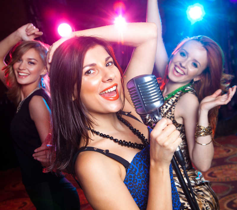 女孩在晚会上对着麦克风唱歌