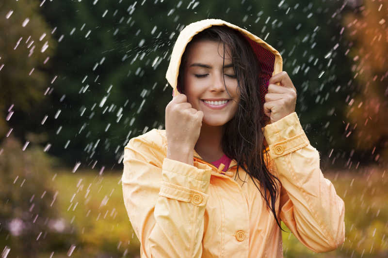 戴着帽子站在雨中的女性