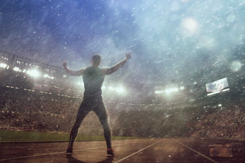 雨中站在体育馆的男人
